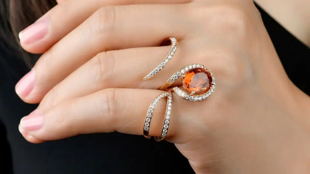 Lionheart two-finger Wildflower cocktail ring in 18-karat gold with diamonds and a spessartite garnet image