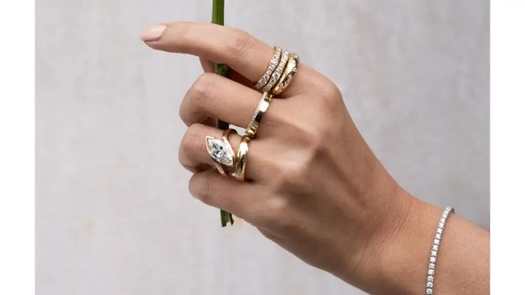 A model wears a selection of rings and a bracelet by The Clear Cut image