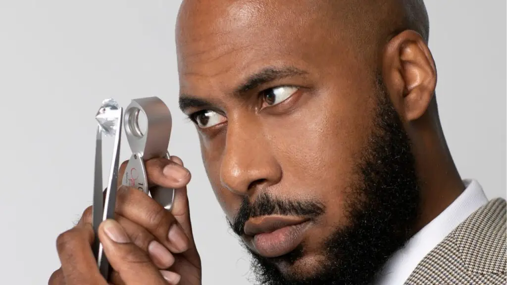 Gaudy Atelier founder Corey Anthony Jones looking at a diamond through a loupe image