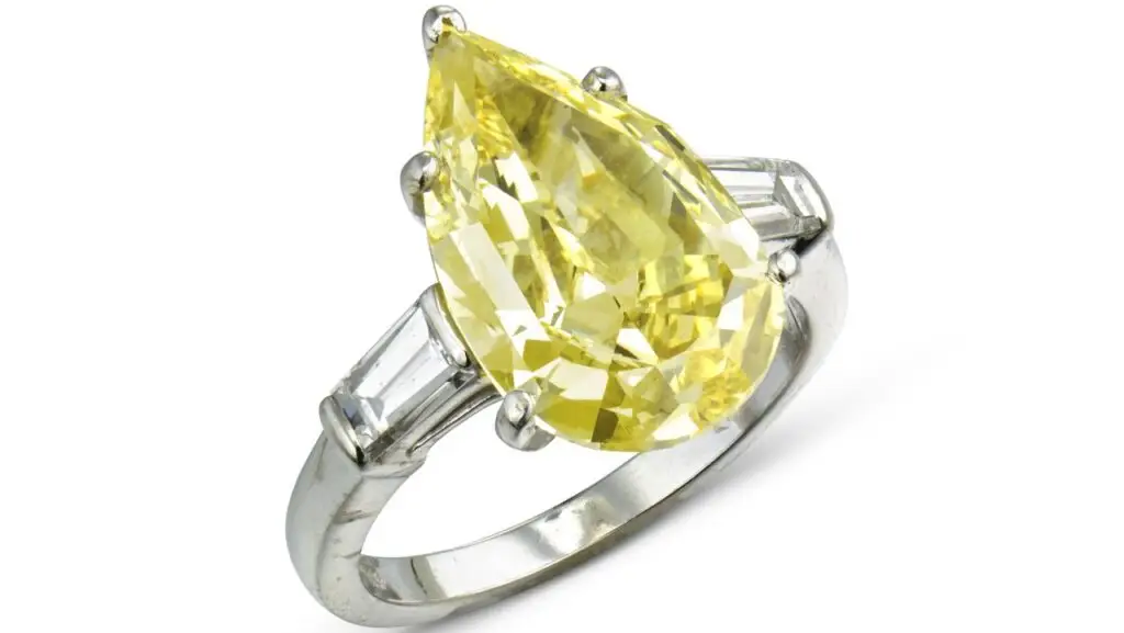 A Bulgari ring bearing a pear mixed-cut, 5.26-carat, fancy-intense-yellow, VS2 diamond between tapered baguette-cut diamonds at Christie's image