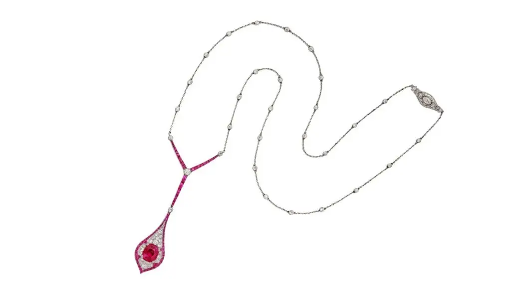 Marcus & Co. necklace sporting a drop-shaped pendant with a cushion-cut, Burmese ruby, surrounded by old European-cut diamonds, and framed and topped by calibré-cut rubies at Sotheby's image