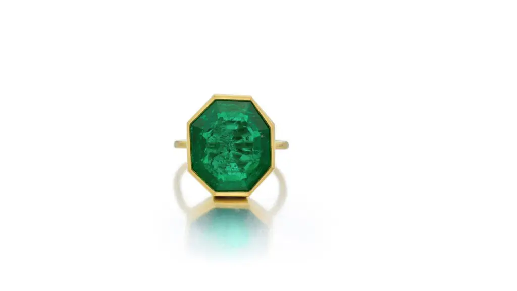 Octagonal-shaped emerald center stone with a bezel settling ring at Sotheby's image