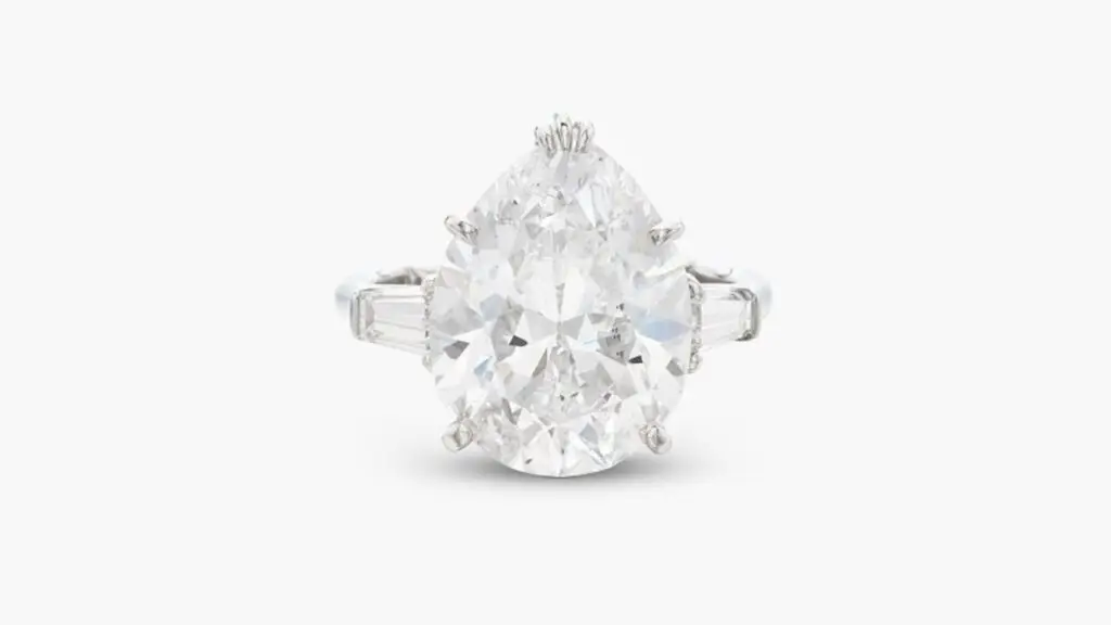A Harry Winston ring bearing a pear-shaped, 6.72-carat, D, VS2 diamond between a pair of tapered-baguette diamonds at Sotheby's image