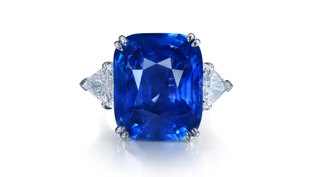Ring set with cushion-shaped Ceylon sapphire flanked by two triangular-cut diamonds at Sotheby's image