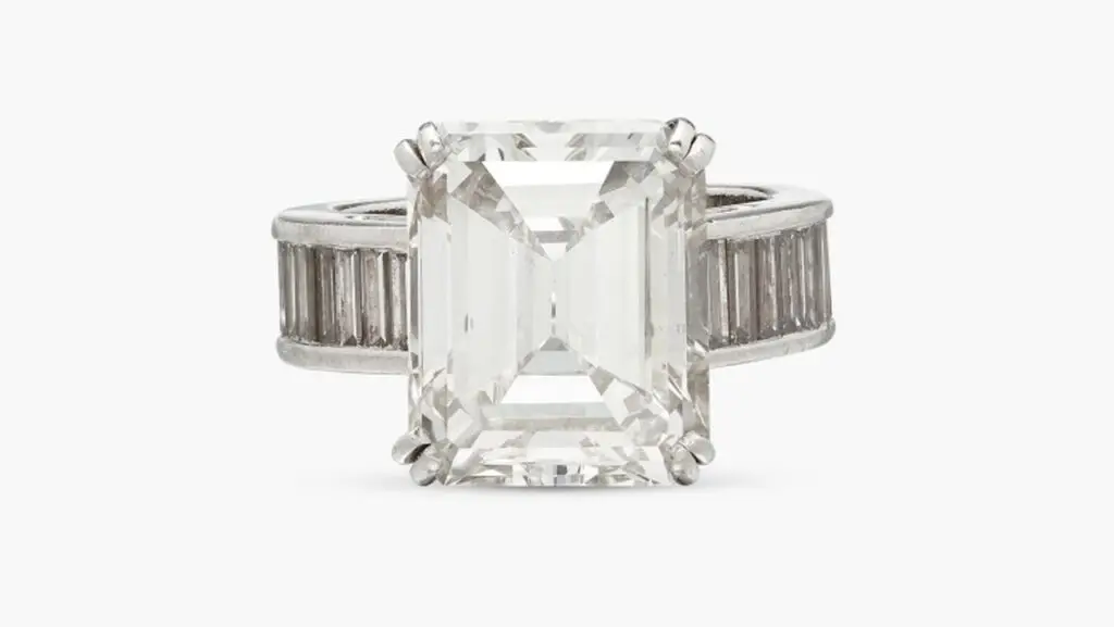 A ring centering an emerald-cut, 9.10-carat, K, VS1 diamond, with about 4 carats of baguette diamonds on the shank at Sotheby's image