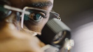 An employee at De Beers sightholder Almod Diamonds viewing a polished stone in Windhoek, Namibia with Ben Perry/Armoury Films/De Beers image