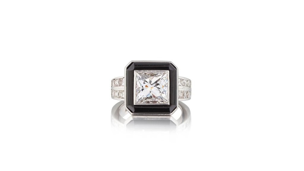 A ring starring a princess-cut diamond in a geometric surround of onyx with princess-cut diamond-set shoulders at Bonhams image