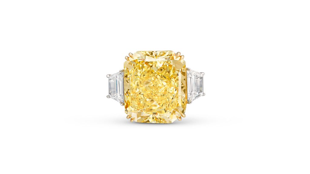A ring with a cut-cornered rectangular modified brilliant-cut, 14.58-carat, fancy-vivid-yellow, internally flawless diamond flanked by trapeze-shaped diamonds at Christie's image