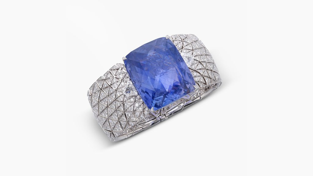 A Cartier bracelet centering a cushion-shaped, 197.80-carat Romanov Ceylon sapphire, with brilliant-cut and modified shield step-cut diamond accents. The piece’s center stone is interchangeable for an engraved rock crystal embellished with triangular diamonds at Sotheby's image