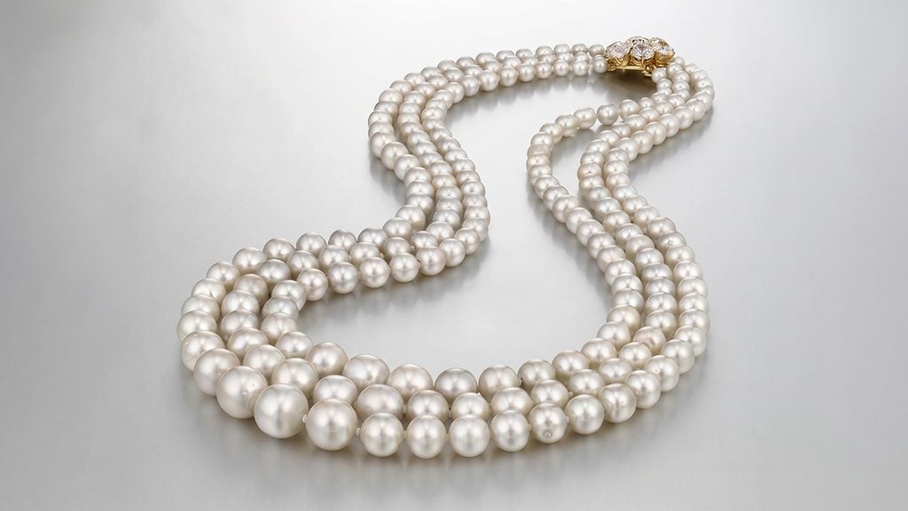 A necklace featuring three rows of natural pearls and a diamond clasp at Christie's image